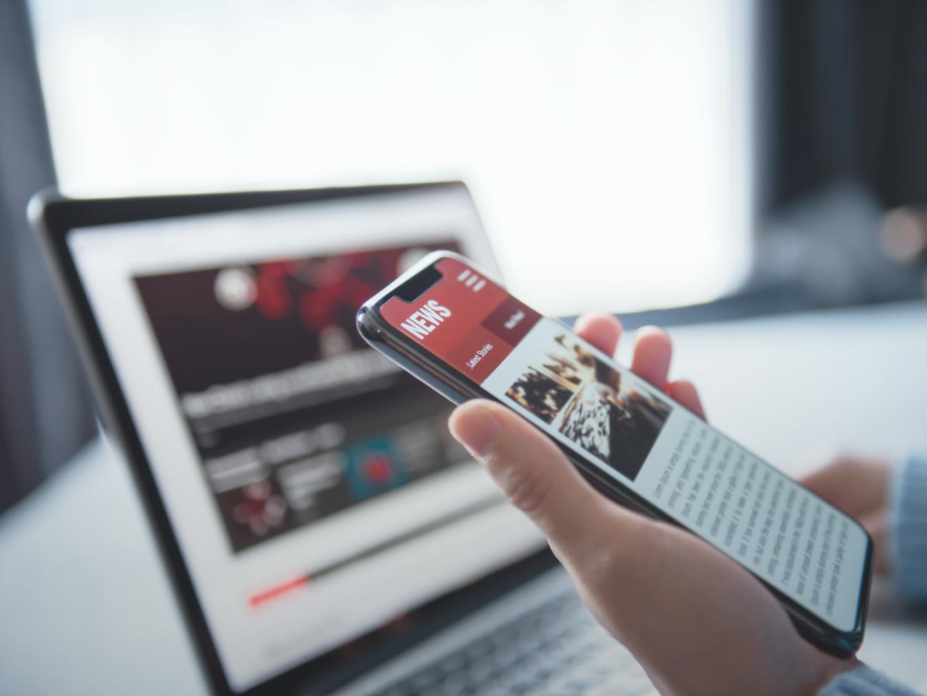 person holding a smart phone showing an article