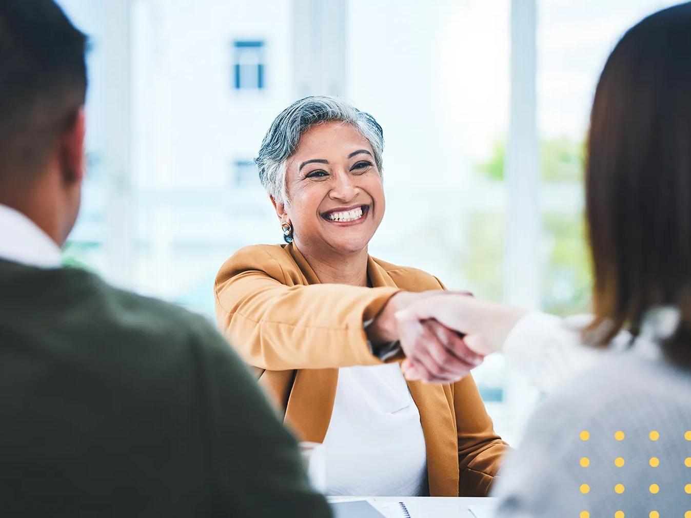 woman shaking hands over a table 