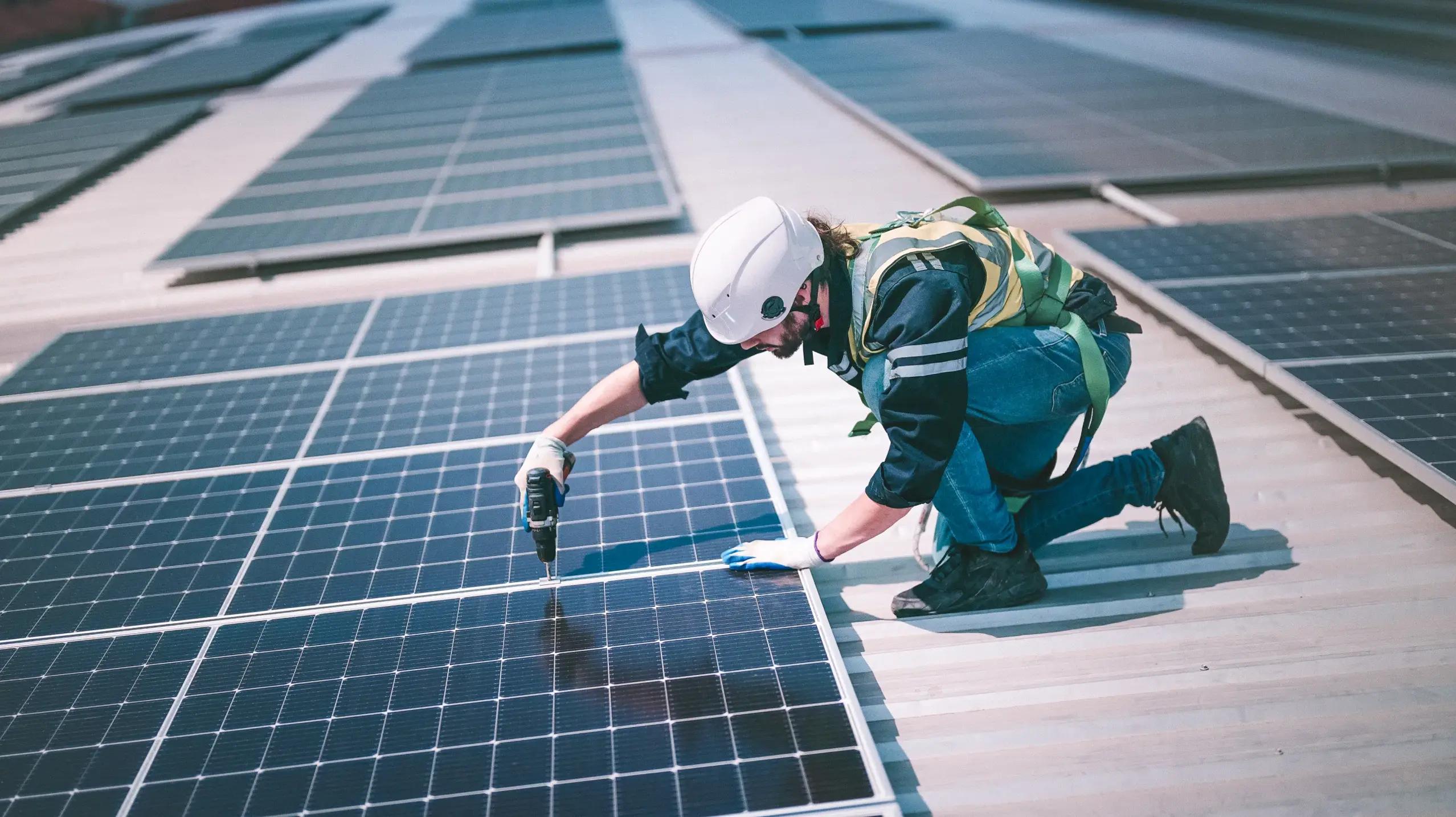 man installing solar panels in protective gear