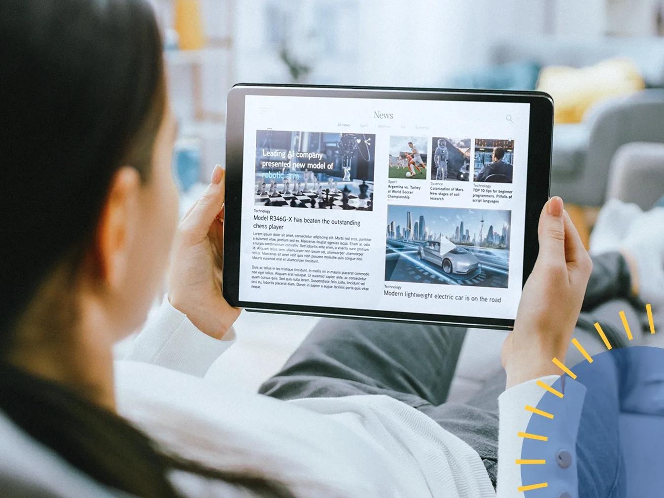 woman looking at a news publication on a tablet