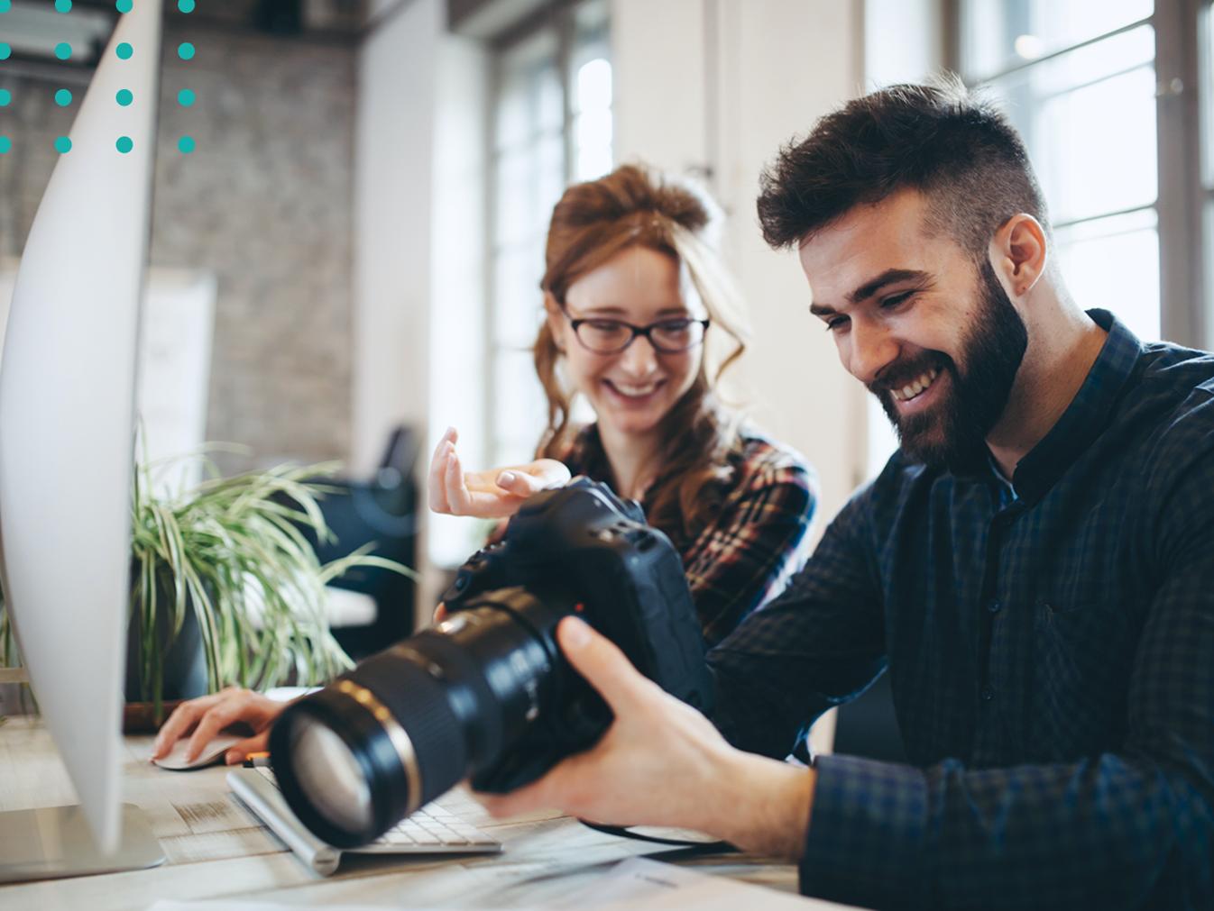 man and woman looking at photos on a digital camera